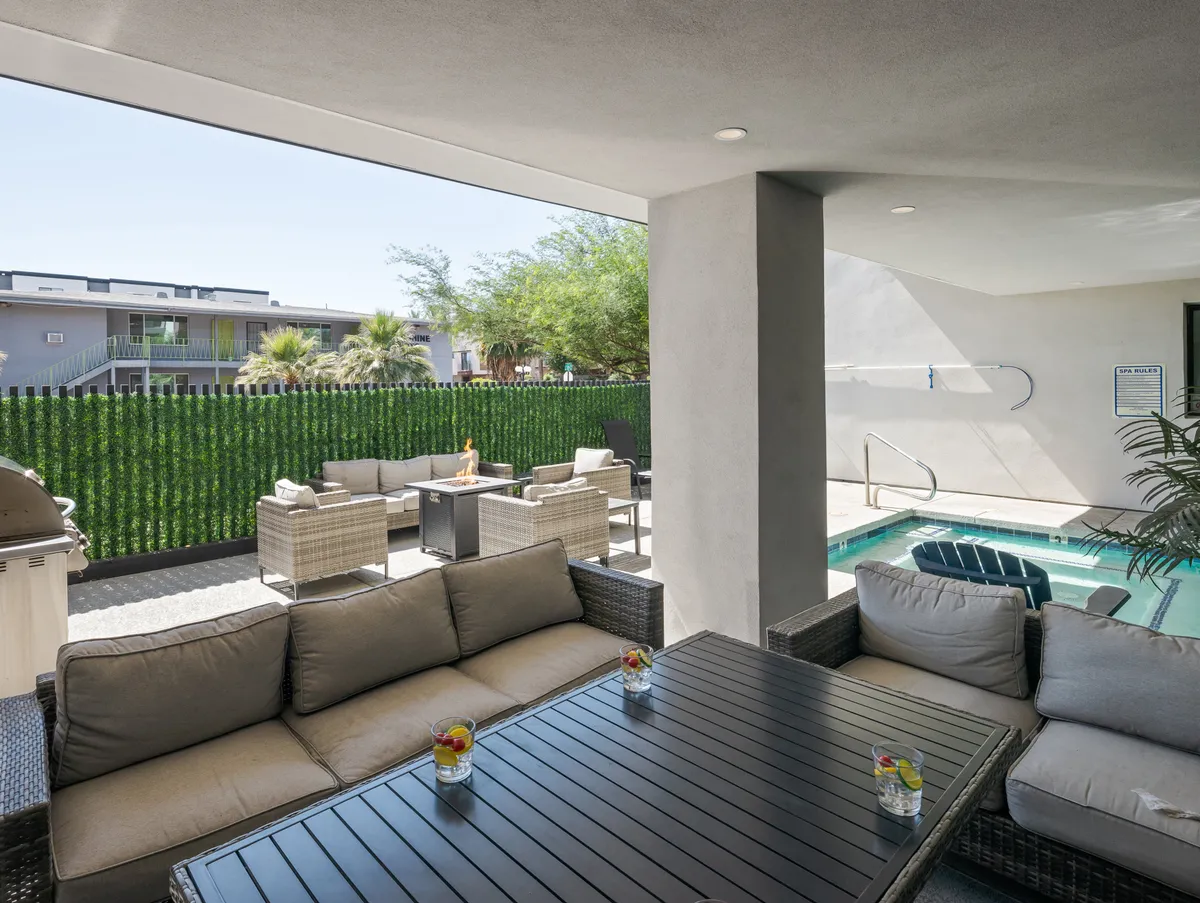 An exterior setting with an outdoor seating area and swimming pool, surrounded by intentional landscaping. The atmosphere is casual and relaxed, suggesting evening gatherings around the fire pit, refreshing dips in the pool, and late-night conversations under the stars.