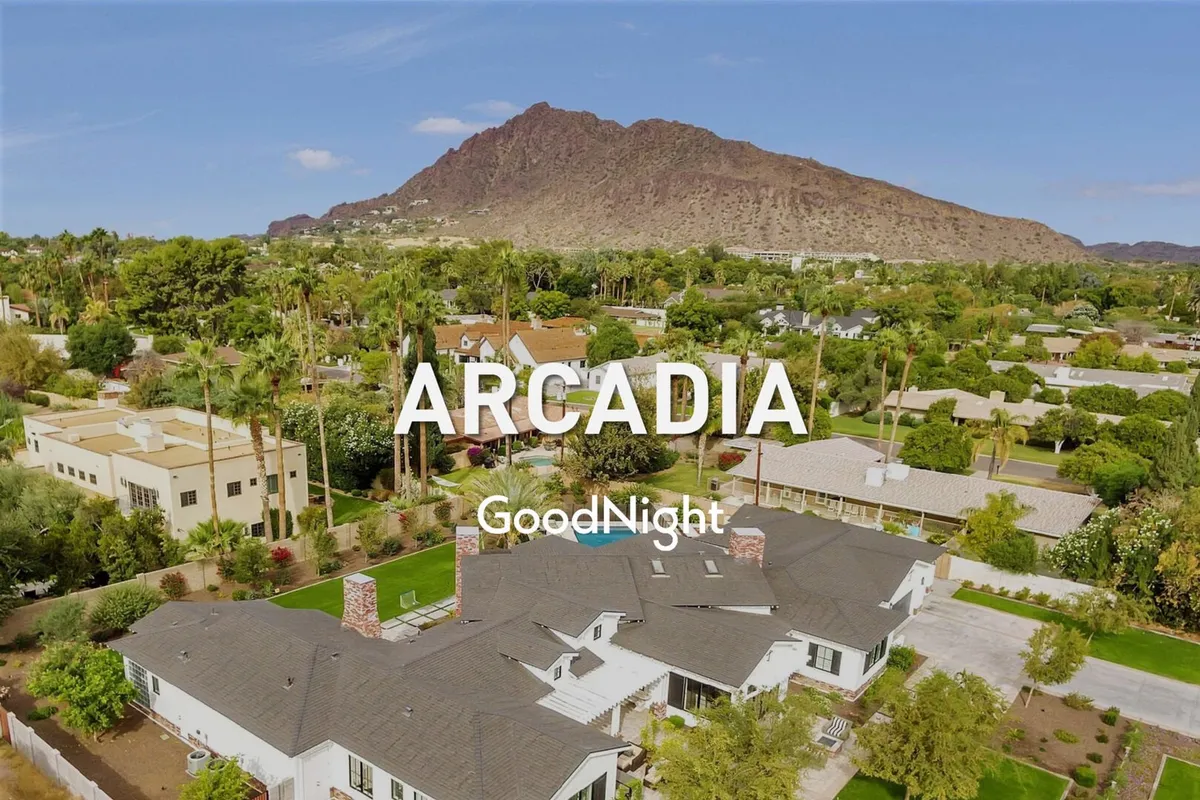 An exterior shot showing the architectural details of a house against a mountain backdrop, with a spacious lawn in the foreground. The atmosphere is serene and inviting, perfect for outdoor relaxation or gatherings.